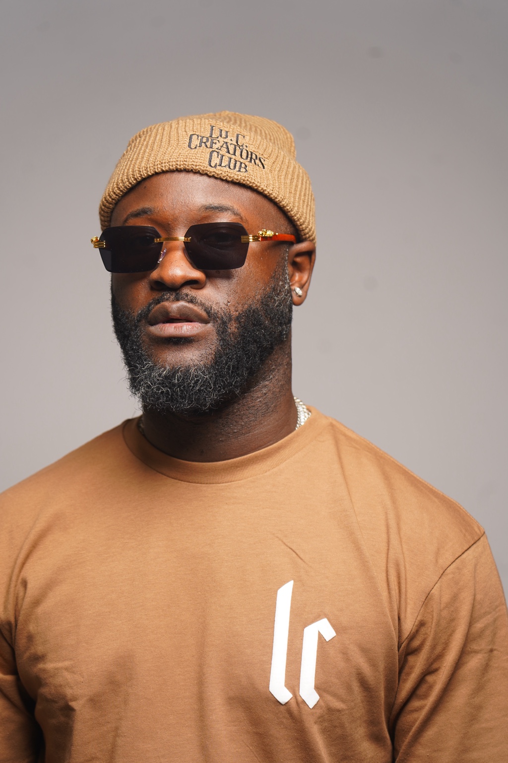 Male creative wearing a tan Lu.C. Creators Club beanie and Lu.C. shirt