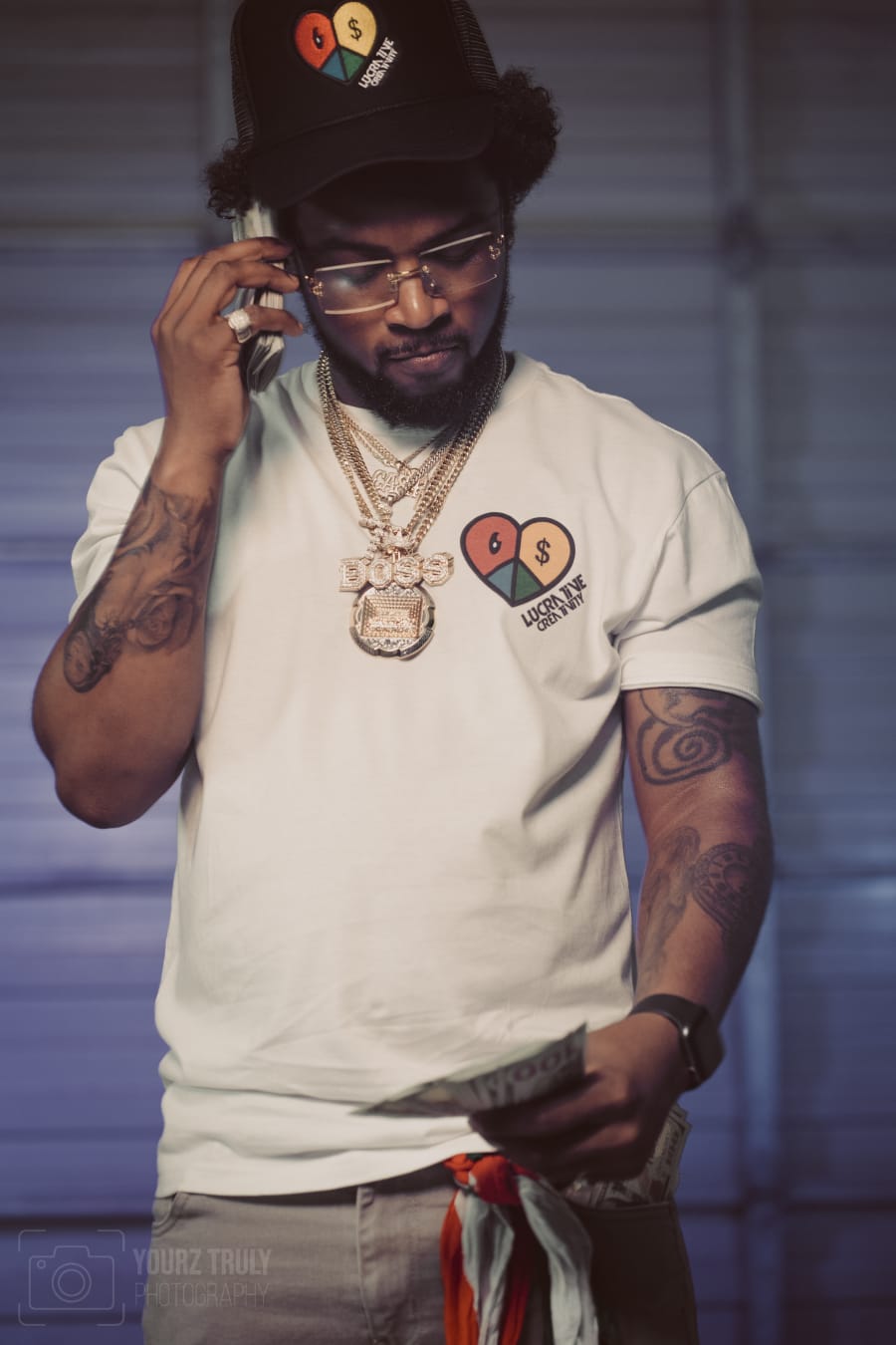 Male creative wearing the Lucrative Creativity heart T-shirt and cap