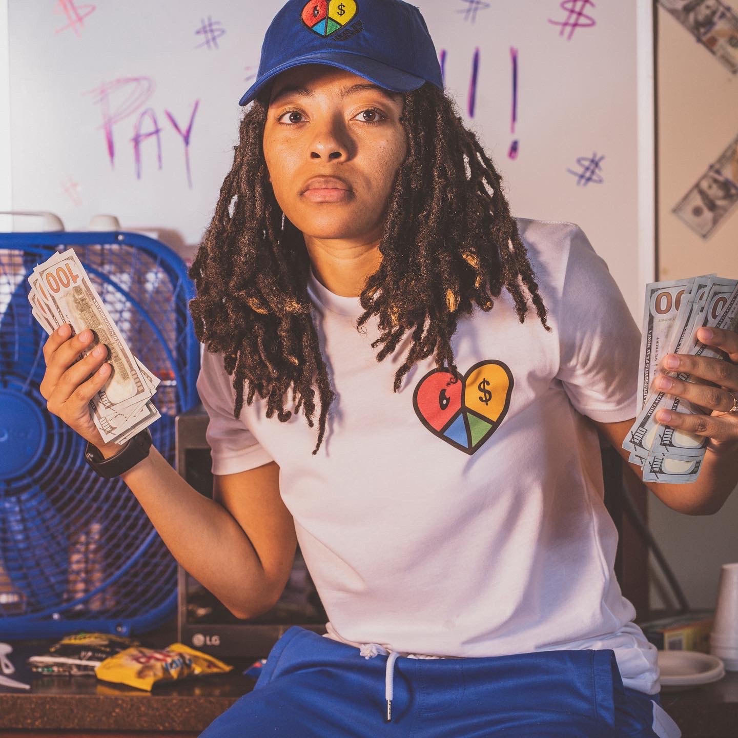 Woman wearing the Lucrative Creativity heart T-shirt and cap