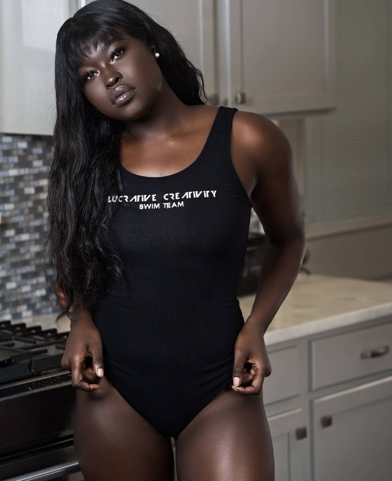 Woman wearing the black Lucrative Creativity Swim Team bodysuit